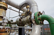 Industrial piping with a green-colored connection and valve wheel 
