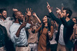 © gstockstudio - Joyful young people toasting with champagne and dancing while enjoying celebration in night club