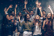 © gstockstudio - Joyful young people dancing and celebrating New Year in the night club while confetti flying around
