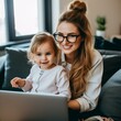 freelance mom works with her kid on her laptop.