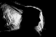 Woman's Long Hair Illuminated By Light, Against A Black Background; Lincoln, Nebraska, United States Of America