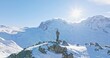 Panoramic landscape of Young asian man standing on top of the famous Gornergrat observatory operates with drone remote control with iconic famous Matterhorn sunset background. Swiss alps, Switzerland.