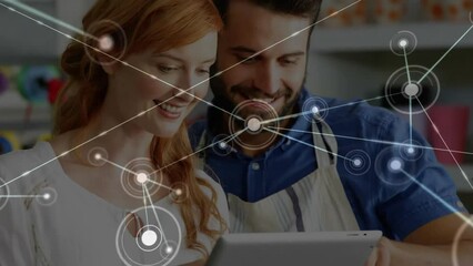 Poster - Animation of network of connections with icons over caucasian man and woman using tablet