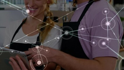 Poster - Animation of network of connections with icons over caucasian man and woman using tablet