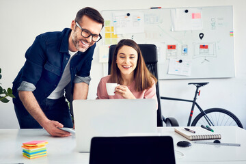 Canvas Print - Two colleagues working together on laptop in office