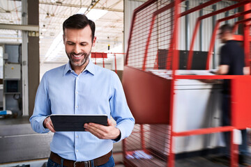 Sticker - Smiling businessman using tablet in a factory