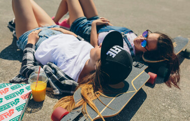 Wall Mural - Two young women with longboards enjoying summer