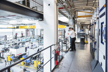 Sticker - Two men talking in factory shop floor