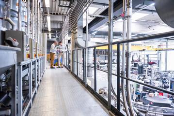 Wall Mural - Two men talking in factory shop floor