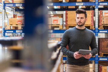 Wall Mural - Man with tablet in factory storeroom looking around