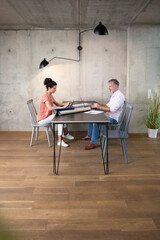 Businessman and businesswoman working at table in a loft