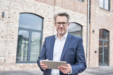 Poster - Portrait of businessman with tablet