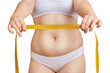 © Galaxy_love_design - Woman shows measuring tape over fat belly background.
