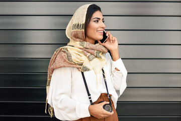 Wall Mural - Spain, Granada, young Arab tourist woman wearing hijab, using smartphone