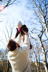 Wall Mural - Father lifting up happy daughter in park