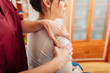 Physiotherapist massaging woman shoulder