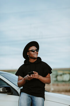 Portrait of a young man sending an email with the phone, laughing