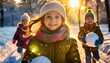 Dziewczynka trzymająca w rękach śnieżną kulę. Dzieci bawiące się na śniegu. Ferie zimowe