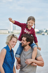 Wall Mural - Germany, Duesseldorf, happy family with daughter at Rhine riverbank