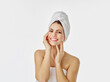 Portrait of smiling woman with hairs wrapped in towel against white background