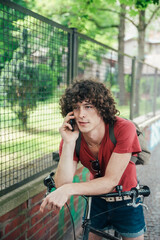 Canvas Print - Young man with bicycle on the phone