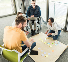 Wall Mural - Happy young business people working together on a project in office