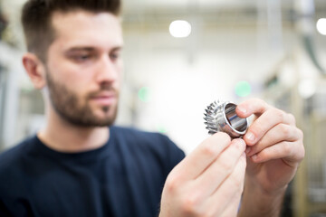 Close-up of man holding workpiece in a factory