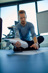 Canvas Print - Businessman organising papers on the floor in office