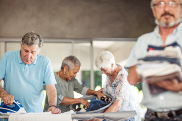 Wall Mural - Seniors ironing clothes together