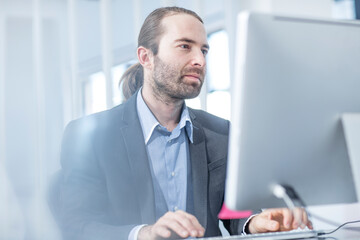 Wall Mural - Businessman in office working on a computer