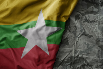 Wall Mural - waving flag of myanmar on the old khaki texture background. military concept.