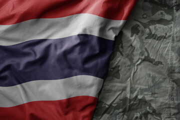 Wall Mural - waving flag of thailand on the old khaki texture background. military concept.