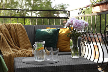 Sticker - Rattan table with jug of water, glasses and beautiful flowers on terrace