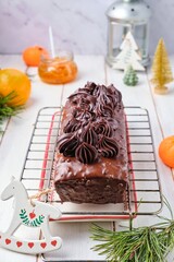 Wall Mural - Step-by-step decoration of a carrot cake with chocolate glaze, ganache and candied fruits in a Christmas style on a light wooden background.