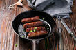 fried sausages on black cast iron pan