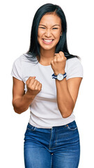 Canvas Print - Beautiful hispanic woman wearing casual white tshirt celebrating surprised and amazed for success with arms raised and eyes closed. winner concept.