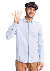 Wall Mural - Young hispanic man wearing casual shirt showing and pointing up with fingers number four while smiling confident and happy.