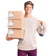 © Krakenimages.com - Young handsome man holding delivery package pointing finger to one self smiling happy and proud