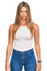 Wall Mural - Young blonde woman wearing casual style with sleeveless shirt skeptic and nervous, frowning upset because of problem. negative person.