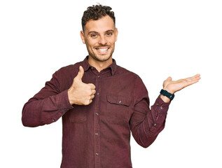 Poster - Young hispanic man wearing casual clothes showing palm hand and doing ok gesture with thumbs up, smiling happy and cheerful