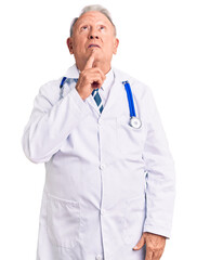 Canvas Print - Senior handsome grey-haired man wearing doctor coat and stethoscope thinking concentrated about doubt with finger on chin and looking up wondering