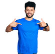 © Krakenimages.com - Young arab man with beard wearing casual blue t shirt looking confident with smile on face, pointing oneself with fingers proud and happy.