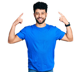 Canvas Print - Young arab man with beard wearing casual blue t shirt smiling pointing to head with both hands finger, great idea or thought, good memory