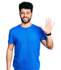 Poster - Young arab man with beard wearing casual blue t shirt showing and pointing up with fingers number five while smiling confident and happy.