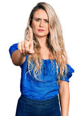 Canvas Print - Young blonde woman wearing casual clothes pointing with finger up and angry expression, showing no gesture