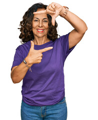 Poster - Middle age hispanic woman wearing casual clothes smiling making frame with hands and fingers with happy face. creativity and photography concept.