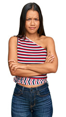 Canvas Print - Beautiful hispanic woman wearing casual clothes skeptic and nervous, disapproving expression on face with crossed arms. negative person.