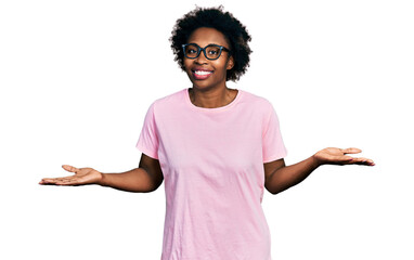 Canvas Print - African american woman with afro hair wearing casual clothes and glasses clueless and confused expression with arms and hands raised. doubt concept.