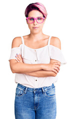 Canvas Print - Young beautiful woman with pink hair wearing casual clothes and glasses skeptic and nervous, disapproving expression on face with crossed arms. negative person.