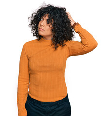 Poster - Young hispanic woman wearing casual clothes confuse and wondering about question. uncertain with doubt, thinking with hand on head. pensive concept.